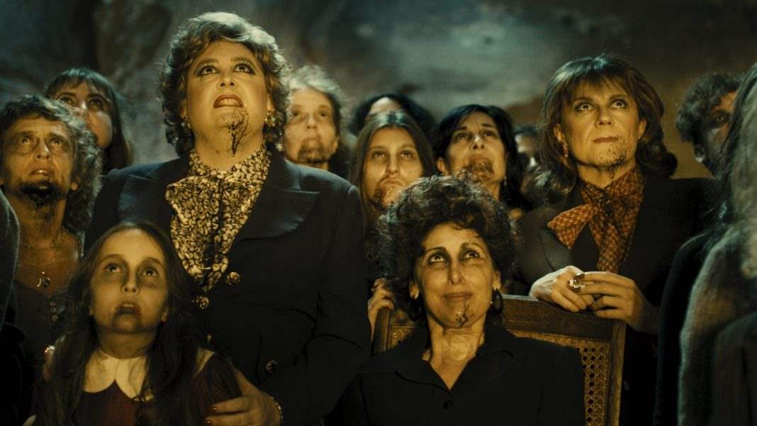 the witches from Witching and Bitching gather in the cave