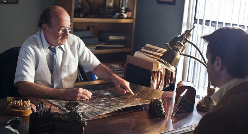 Exhume review photo of two characters at a desk